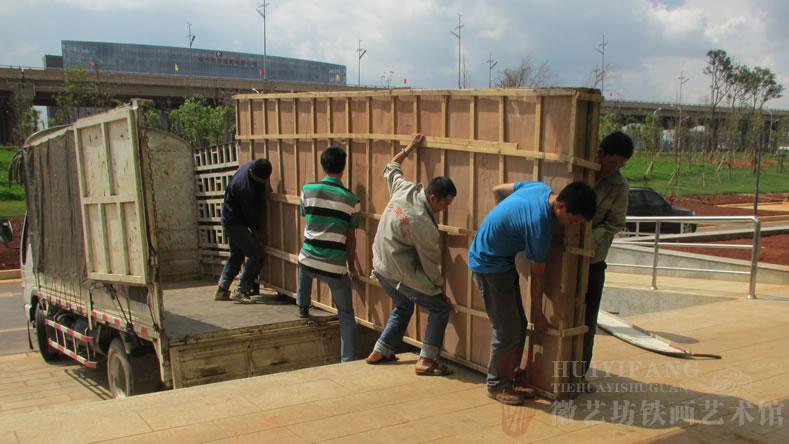 昆明長水國際機場定制的辦公樓大廳大型紅木迎客松鐵畫屏風(fēng)-正在搬運鐵畫屏風(fēng)包裝箱