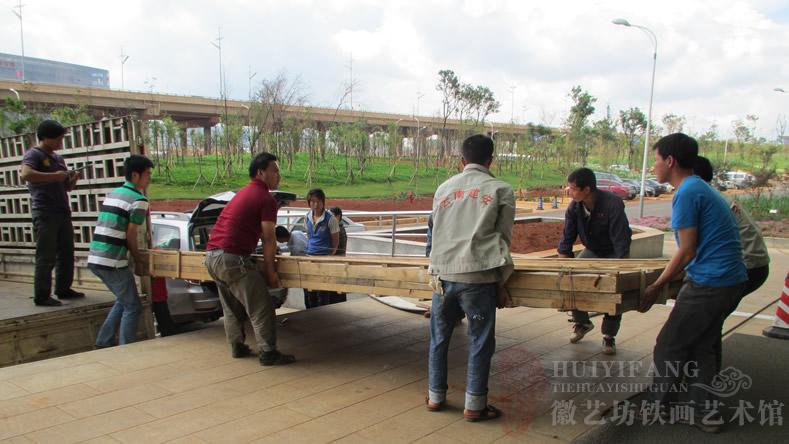 昆明長水國際機場定制的辦公樓大廳大型紅木迎客松鐵畫屏風(fēng)-正在搬運鐵畫屏風(fēng)包裝箱